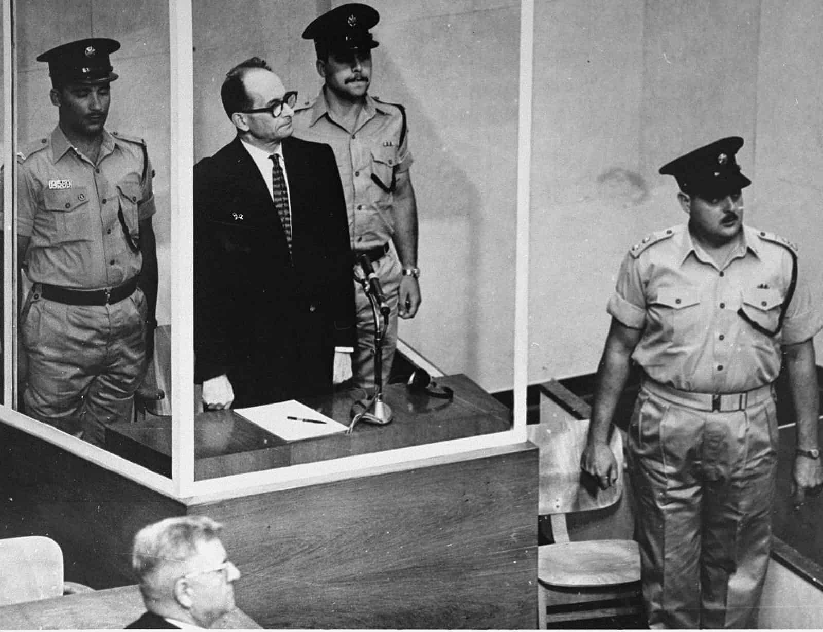 Poză despre Adolf Eichmann într-o sală de judecată în Israel.