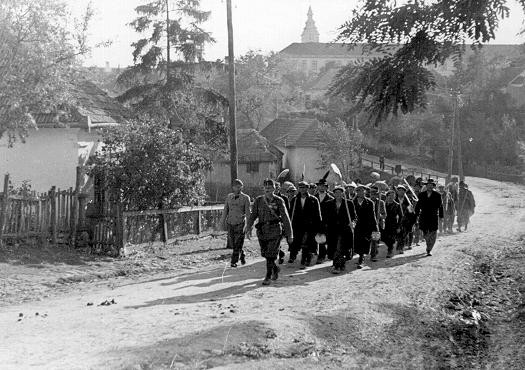 Poza conține o coloană de muncitori evrei la muncă forțată în marș. Sárospatak, Ungaria, 1941.